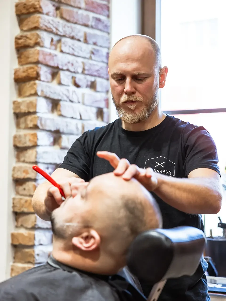 Barber z Le Barber při holení břitvou